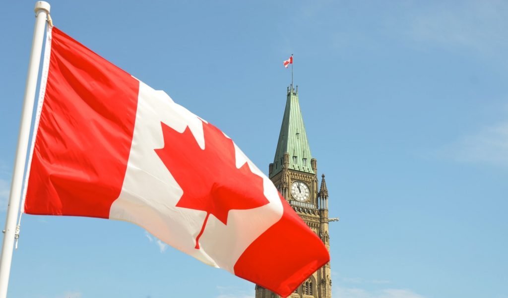 Canada-flag-parliament-jason-hafso-C2keINMOhIE-unsplash-1024x601.jpg