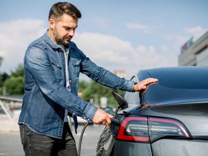 Man-charging-electric-car-EV-Depositphotos_395747160_S-670x504.jpg